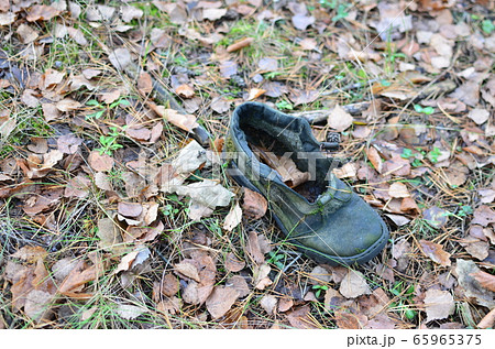 Man's shoes on a ground in the forest. Territory designation as a sign that there was a person here Man's shoes on a ground in the forest. Territory designation as a sign that there was a person here 65965375