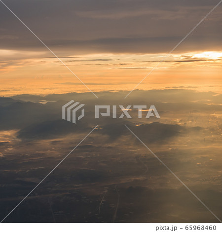 Beautiful sunrise view above the clouds with dramatic light from airplace window. Beautiful sunrise view above the clouds with dramatic light from airplace window. 65968460