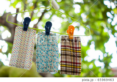 Closed up three brightly colored fabric handmade were washed and dried under the shade of the backyard. Which a beautiful bokeh. People like to use it as an extension of the mask. Closed up three brightly colored fabric handmade were washed and dried under the shade of the backyard. Which a beautiful bokeh. People like to use it as an extension of the mask. 65969463