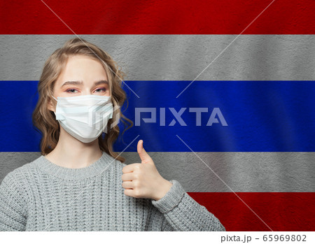 Happy woman in face mask holding thumb up on Thai Happy woman in face mask holding thumb up on Thai 65969802