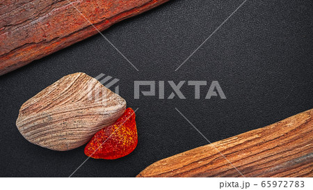 Natural amber. A piece of yellow transparent natural amber on a piece of textured wood Natural amber. A piece of yellow transparent natural amber on a piece of textured wood 65972783