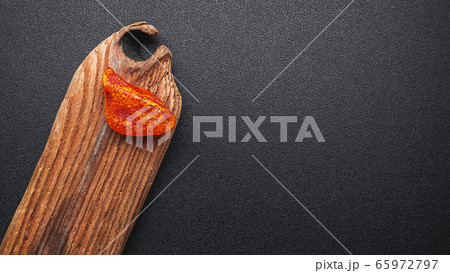 Natural amber. A piece of yellow transparent natural amber on a piece of textured wood Natural amber. A piece of yellow transparent natural amber on a piece of textured wood 65972797