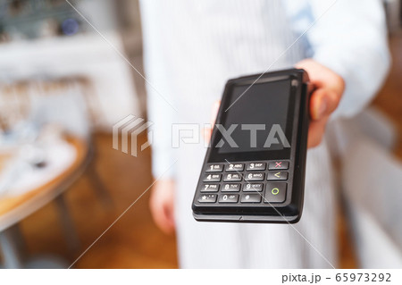 Young man holding terminal for contactless payment Young man holding terminal for contactless payment 65973292