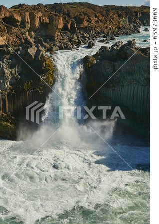 The Power of Nature. Amazing view of the old volcanic cliff with small waterfall in Iceland, Europe. Powerful mountain river. Icelandic nature landscape The Power of Nature. Amazing view of the old volcanic cliff with small waterfall in Iceland, Europe. Powerful mountain river. Icelandic nature landscape 65973669
