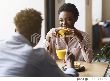 Happy African American couple on first date in cafe, talking and enjoying each other 65974589