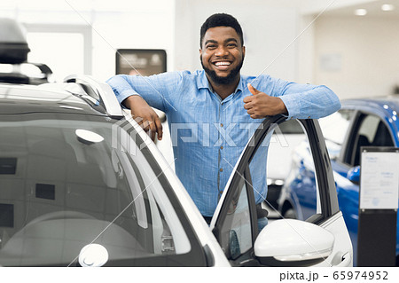 African Man Gesturing Thumbs-Up Approving Automobile After Test-Drive In Dealership 65974952