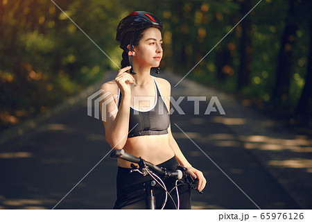 Sports woman riding bikes in summer forest Sports woman riding bikes in summer forest 65976126