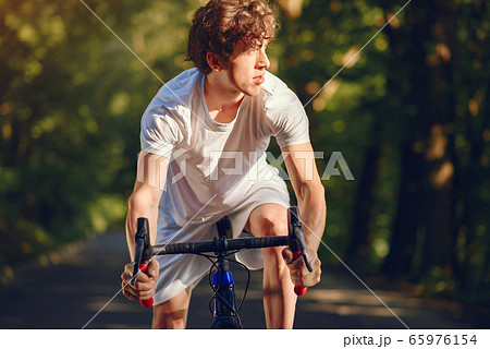 Sports man riding bike in summer forest 65976154