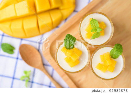 Thai dessert mango pudding, ripe mango dip in agar and coconut milk jelly on top  in the glass  65982378