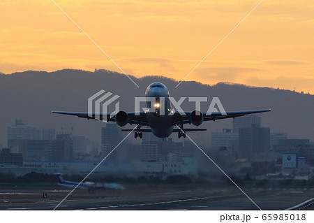 朝陽の中でこれから離陸しようとしている飛行機の前姿 65985018