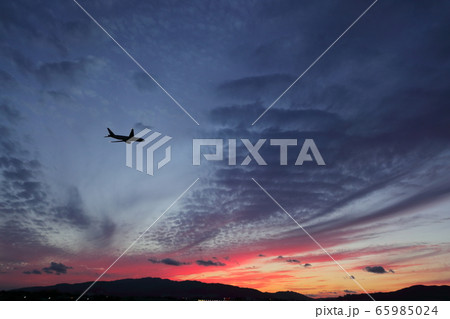 夕焼けの空に向かって飛び立っていく飛行機 夕焼けの空に向かって飛び立っていく飛行機 65985024