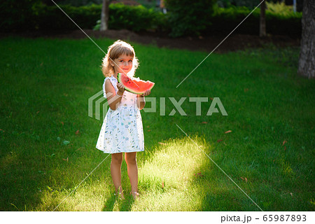 Cute little girl eating watermelon and enjoying picnic Cute little girl eating watermelon and enjoying picnic 65987893
