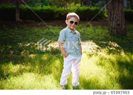 Happy little boy with sunglasses in the garden. Happy little boy with sunglasses in the garden. 65987903