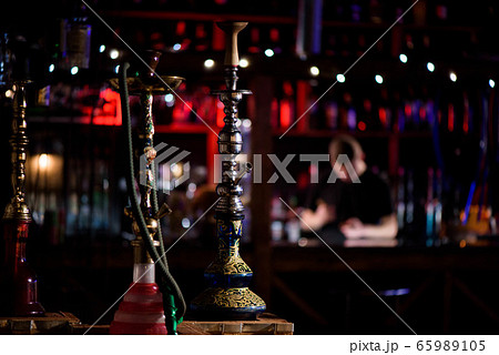 Barman fills black burnt ceramic bowl for hookah Barman fills black burnt ceramic bowl for hookah 65989105