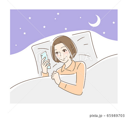 布団の中でスマホを見る笑顔の女性 布団の中でスマホを見る笑顔の女性 65989703