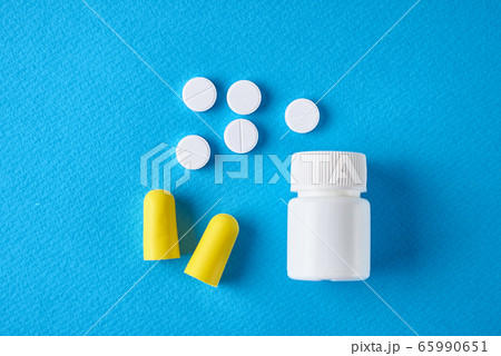 Insomnia problem concept. Ear plugs and pills on a 65990651