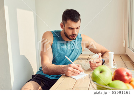 Handsome gentleman holding pills and making notes 65991165