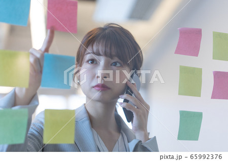 付箋を見ながらミーティングする女性 65992376