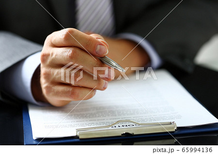 Male arm in suit and tie fill form clipped to pad 65994136