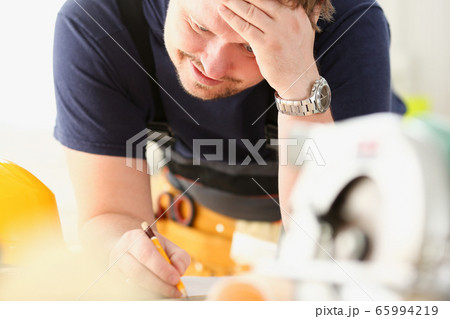 Arms of worker making structure plan on scaled paper 65994219