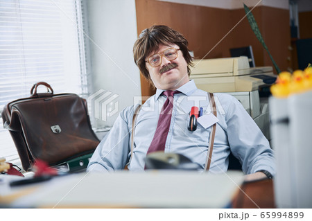 Relaxed plus size adult man in retro office alone Relaxed plus size adult man in retro office alone 65994899