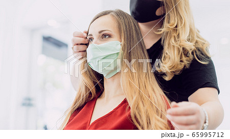 Woman with fresh hair styling in haircutters shop with face mask Woman with fresh hair styling in haircutters shop with face mask 65995712