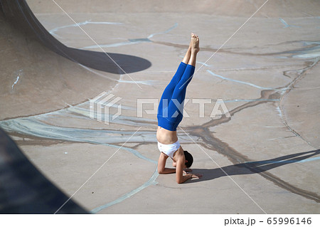 Asian chinese woman doing street yoga in public Asian chinese woman doing street yoga in public 65996146