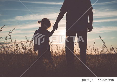 Father and sad son standing in the park at the 66004996