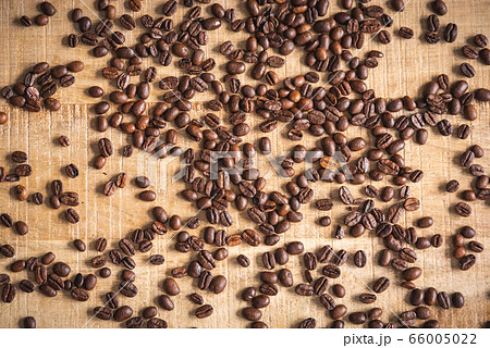 Roasted brown coffee beans spilled on wooden table 66005022