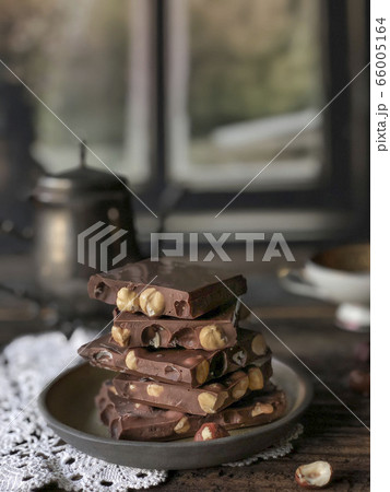 stack of chocolate bars with nuts on a wooden 66005164