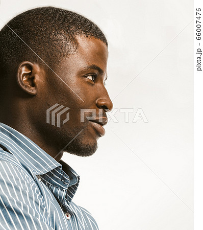 Confidently African American man delicately smiling looking at right side with textspace. Young dark-skinned businessman isolated on white background. Profile view. Close up bottom shot. Toned image Confidently African American man delicately smiling looking at right side with textspace. Young dark-skinned businessman isolated on white background. Profile view. Close up bottom shot. Toned image 66007476