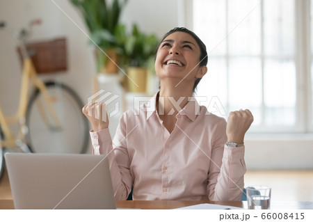 Euphoric young indian businesswoman feeling excited about professional achievement. 66008415