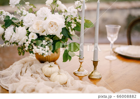 Closeup of a wooden table decorated for a wedding dinner. Closeup of a wooden table decorated for a wedding dinner. 66008882
