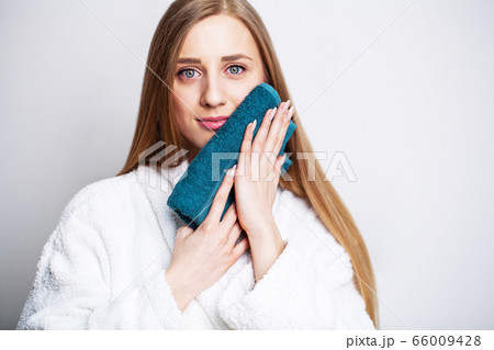 Face care, beautiful woman wipes her face with a towel after taking a shower Face care, beautiful woman wipes her face with a towel after taking a shower 66009428