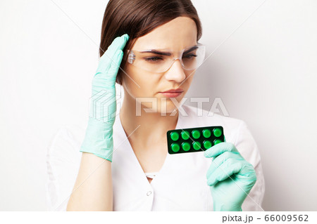 Doctor in a white coat holding a pill for a healthy sex life of men 66009562