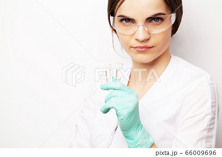 Female doctor in laboratory holding holding test tubes with experimental antiviral vaccine Female doctor in laboratory holding holding test tubes with experimental antiviral vaccine 66009696