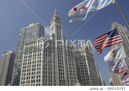 Wrigley Building and Tribune Tower on Michigan Avenue with Illinois flag on the foreground in Chicago, USA Wrigley Building and Tribune Tower on Michigan Avenue with Illinois flag on the foreground in Chicago, USA 66010281