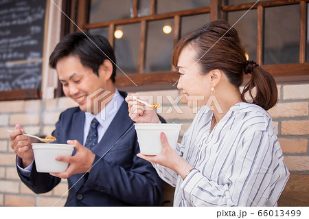 テイクアウトのカレーを食べる男女 66013499