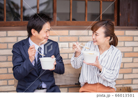 テイクアウトのカレーを食べる男女 66013501