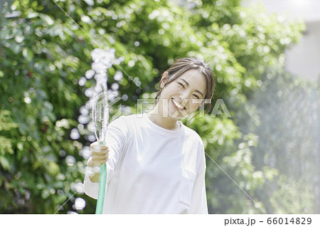 若い女性 水まき 夏のイメージの写真素材 若い女性 水まき 夏のイメージの写真素材