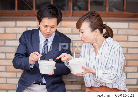 テイクアウトのカレーを食べる男女 66015021