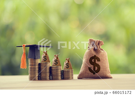 Black graduation cap, Hat and US dollar bag on rows of rising coins,  on a table. Education funding, financial concept. Depicts savings for child knowledge for future studies 66015172