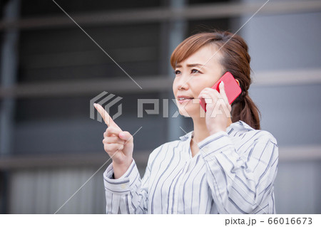 スマホで電話しながら怒るアジア人ビジネスウーマン 66016673