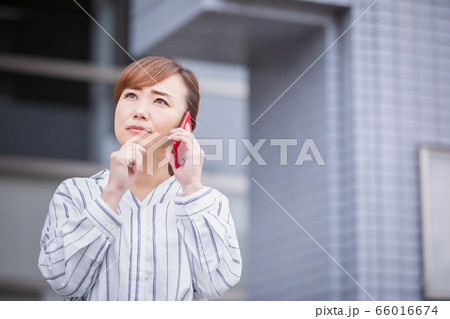 スマホで電話しながら困るアジア人ビジネスウーマン 66016674