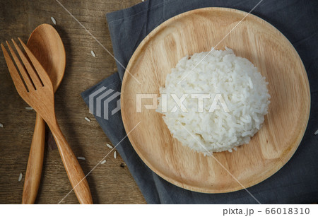 Cooked rice with a spoon and fork on wooden table 66018310
