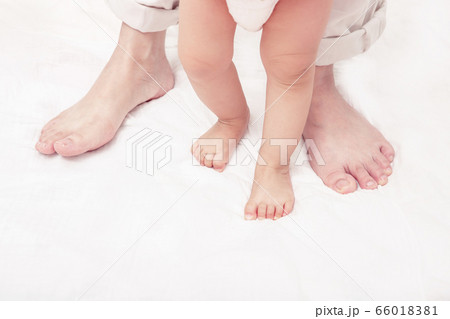 First steps. Baby learning to walk, with help of mothers and fathers. (Soft focus and blurry) 66018381