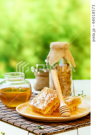 Honeycomb with jar and bee pollen on white wooden 66018573