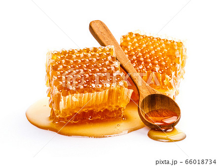 Honeycomb with honey spoon isolated on white background Honeycomb with honey spoon isolated on white background 66018734