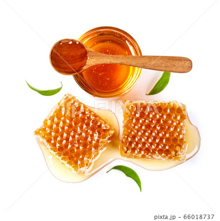 Honeycomb with jar and honey spoon and leaf isolated on white background 66018737