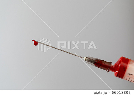 Syringe with a blood sample. A drop of blood at the end of the needle. Blood chemistry. Blood test for viruses. Syringe with a blood sample. A drop of blood at the end of the needle. Blood chemistry. Blood test for viruses. 66018802
